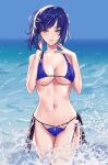  1girl absurdres bangs bare_arms bare_shoulders bikini blue_bikini blue_hair blue_sky blunt_bangs breasts commentary cowboy_shot day genshin_impact green_eyes grin hands_up highres ira_town large_breasts looking_at_viewer navel ocean outdoors purple_lips short_hair sky smile solo standing stomach swimsuit thighs wading water yelan_(genshin_impact) 