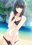  1girl bangs bare_arms bare_shoulders beach bikini bikini_pull black_bikini black_hair blurry blurry_background breasts brown_eyes clothes_pull cowboy_shot dutch_angle female_pubic_hair finger_to_mouth grin groin halterneck highres light_blush medium_hair nagami_yuu navel ocean original pubic_hair rock sand shushing sidelocks skinny small_breasts smile solo stomach striped striped_bikini swimsuit 