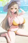  1girl :d bangs barefoot bikini blonde_hair blue_archive blush breasts cleavage collarbone commentary green_eyes halo hat huge_breasts looking_at_viewer marota navel nonomi_(blue_archive) nonomi_(swimsuit)_(blue_archive) ocean outdoors parted_lips side-tie_bikini sideboob sitting smile solo swimsuit thighs twitter_username wariza water white_headwear yellow_bikini 