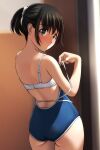  1girl absurdres ass bare_arms bare_shoulders black_hair blue_swimsuit blurry blurry_background blush bra brown_eyes depth_of_field from_behind hair_ornament hair_scrunchie hand_up highres indoors looking_at_viewer looking_back matsunaga_kouyou nose_blush one-piece_swimsuit original parted_lips ponytail scrunchie sidelocks solo swimsuit underwear white_bra white_scrunchie 