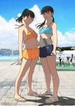  2girls bare_shoulders bikini bikini_skirt black_hair blue_bikini blue_sky blunt_bangs blurry cellphone closed_mouth cloud cloudy_sky cumulonimbus_cloud day denim denim_shorts depth_of_field frilled_bikini_top full_body grin halterneck highres mole mole_under_mouth multiple_girls navel orange_bikini original outdoors parted_bangs phone polka_dot polka_dot_bikini ponytail selfie_stick shinchou_ni_kansuru_kousatsu short_hair shorts sky slippers smartphone smile standing strap strapless swimsuit tube_top twintails white_slippers 