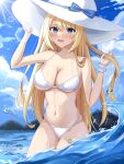  1girl absurdres bare_shoulders bikini blonde_hair blue_eyes blue_sky blush breasts cleavage cloud cowboy_shot day hat highres kuon_(kuon) large_breasts long_hair looking_at_viewer masquerade_channel mountain navel ocean open_mouth outdoors sky smile soaking_feet solo standing sun_hat swimsuit teeth upper_teeth virtual_youtuber water white_bikini white_headwear yumemiya_alice 