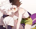  2boys bare_shoulders black_hair blue_eyes boy_on_top brown_eyes child commentary_request face-to-face gon_freecss green_shorts highres hunter_x_hunter killua_zoldyck male_child male_focus multiple_boys open_mouth shirt short_hair shorts spiked_hair tank_top turtleneck white_hair white_shirt white_tank_top yomi4310 