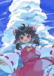  1girl :d ascot bangs black_hair blue_sky bow cloud cowboy_shot detached_sleeves frilled_skirt frills from_below hair_bow hair_tubes hakurei_reimu highres kibisake looking_at_viewer medium_hair open_mouth outdoors red_bow red_eyes red_shirt red_skirt ribbon-trimmed_sleeves ribbon_trim shirt skirt sky smile solo standing touhou wide_sleeves yellow_ascot 