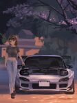  1girl bangs black_footwear black_shirt blush bracelet brown_eyes brown_hair cherry_blossoms closed_mouth commentary_request highres jewelry long_hair looking_at_viewer mazda mazda_rx-7 midriff momo_hiki navel original outdoors pants shirt shoes short_sleeves smile solo spoiler_(automobile) tree walking white_pants 