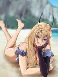  1girl antennae azur_lane bangs bare_legs bare_shoulders barefoot beach between_breasts blonde_hair blue_one-piece_swimsuit blurry blurry_background blush breasts crossed_arms elbow_gloves feet flower full_body gloves hair_flower hair_ornament hand_on_own_cheek hand_on_own_face highres kumano_(azur_lane) kumano_(fancy_waves)_(azur_lane) legs legs_up long_hair looking_at_viewer lying medium_breasts mi_settei ocean official_alternate_costume on_ground on_stomach open_mouth parted_lips purple_eyes sand single_glove smirk soles solo swimsuit teeth 