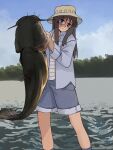  1girl animal blue_jacket blue_shorts brown_eyes brown_hair bucket_hat catfish cloud commentary cordrawroy english_commentary expressionless fish glass hat highres holding holding_animal holding_fish in_water jacket lake long_hair long_sleeves minakami_mai nichijou shirt shorts sidelocks sky solo standing striped striped_shirt tree water yellow_headwear 