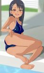 1girl aruman ass bare_shoulders barefoot black_hair blue_one-piece_swimsuit blurry blurry_background blush breasts brown_eyes collarbone commentary competition_school_swimsuit dark-skinned_female dark_skin fang groin hair_ornament hairclip hand_on_own_thigh highres ijiranaide_nagatoro-san indoors long_hair looking_at_viewer lying nagatoro_hayase on_floor on_side pool school_swimsuit skin_fang small_breasts soles solo swimsuit thighs toes 