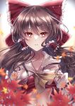  1girl ascot bangs blurry blurry_foreground bow brown_hair collarbone hair_bow hair_tubes hakurei_reimu highres leaf long_hair looking_at_viewer maple_leaf mashiropuni midriff parted_lips red_bow red_eyes solo touhou upper_body yellow_ascot 
