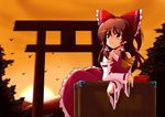  bow box brown_eyes brown_hair detached_sleeves donation_box food hair_bow hakurei_reimu pocky poco_(pocoyb) short_hair solo sunset torii touhou 