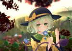  1girl absurdres black_hat blue_flower blurry bow buttons chinese_commentary closed_mouth collared_shirt commentary_request depth_of_field diamond_button eyeball flower frilled_shirt_collar frilled_sleeves frills green_eyes green_hair hat hat_bow highres holding holding_flower incredibly_absurdres komeiji_koishi long_sleeves looking_at_viewer morning_glory outdoors shirt short_hair smile solo third_eye touhou upper_body wide_sleeves wrainman yellow_bow yellow_shirt 