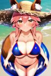  1girl absurdres animal_ear_fluff animal_ears awayuki_uyuko bikini blue_bikini blush breasts cleavage collarbone ears_through_headwear fate/grand_order fate_(series) fox_ears fox_girl fox_tail hat highres innertube large_breasts navel ocean outdoors pink_hair side-tie_bikini_bottom smile solo straw_hat swimsuit tail tamamo_(fate) tamamo_no_mae_(swimsuit_lancer)_(fate) 