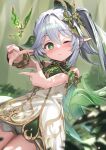  1girl bare_shoulders blurry blurry_background blush bracer closed_mouth colored_tips cowboy_shot cross-shaped_pupils crystalfly_(genshin_impact) depth_of_field dot_nose dress genshin_impact gold_trim green_eyes green_hair hair_between_eyes hair_intakes hair_ornament highres kanzarin leaf_hair_ornament long_hair multicolored_hair nahida_(genshin_impact) one_eye_closed picture_frame side_ponytail sidelocks smile solo streaked_hair symbol-shaped_pupils thighs two-tone_hair white_dress white_hair 