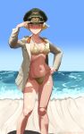  1girl adjusting_clothes adjusting_headwear beach bikini blonde_hair blue_sky breasts brown_eyes commentary_request erwin_(girls_und_panzer) girls_und_panzer goggles goggles_on_headwear hand_on_own_hip hat highres jacket jewelry looking_at_viewer military_hat military_jacket necklace ocean peaked_cap pharaohetcaesar short_hair sky smile solo standing swimsuit twitter_username 