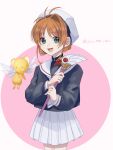  1girl brown_hair cardcaptor_sakura female_child green_eyes happy highres holding kero kinomoto_sakura open_mouth sailor_collar school_uniform skirt tomoeda_elementary_school_uniform twitter_username white_sailor_collar white_skirt wings yumezu_(yu_me_zu) 