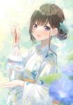  1girl :d amamine animal bag bagged_fish bangs black_hair blue_flower blurry blurry_foreground commentary_request day depth_of_field fish floral_print flower goldfish hair_bun hair_flower hair_ornament holding japanese_clothes kimono long_sleeves looking_at_viewer original outdoors print_kimono purple_eyes smile solo water white_kimono wide_sleeves 