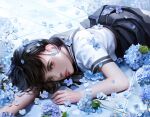  1girl black_eyes black_hair blue_flower blurry brown_eyes closed_mouth depth_of_field english_commentary expressionless flower highres looking_at_viewer lying on_stomach original sailor_collar school_uniform shadow short_hair short_sleeves sideways_glance skirt solo yeonjun_park 