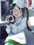  1girl baseball_cap black_hair blush camera cat closed_eyes earrings english_text glasses green_skirt hat highres holding holding_camera hood hoodie hoop_earrings idolmaster idolmaster_shiny_colors jewelry long_hair long_sleeves menu_board mitsumine_yuika open_mouth pachiko print_hat road skirt smile solo street traffic_cone white_hat white_hoodie 