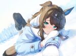  1girl animal_ears ankle_boots aqua_eyes bangs black_footwear blue_coat blush boots brown_hair closed_mouth coat daring_tact_(umamusume) day fur-trimmed_boots fur-trimmed_coat fur_trim highres horse_ears horse_girl horse_tail horseshoe kashmir_0808 long_hair long_sleeves looking_at_viewer lying on_ground on_stomach outdoors smile snow solo swept_bangs tail umamusume white_mittens winter 