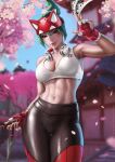  1girl black_pants blurry blurry_background breasts brown_eyes cherry_blossoms cowboy_shot crop_top dandon_fuga facial_mark fingerless_gloves fox_mask gloves green_hair headphones headphones_around_neck highres holding holding_knife kiriko_(overwatch) knife kunai mask medium_breasts midriff navel overwatch pants solo tank_top toned two-tone_gloves weapon white_tank_top 