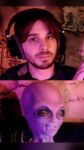  1boy alien closed_mouth facial_hair gnorts_(vinesauce) headphones headset looking_at_viewer map non-web_source off-topic photo_(medium) portrait real_life short_hair vinesauce vinny_(vinesauce) 