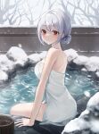  1girl back bangs bare_arms bare_shoulders bare_tree blush breasts bucket closed_mouth fence grey_hair hair_bun heeri highres long_hair looking_at_viewer looking_to_the_side medium_breasts naked_towel onsen original red_eyes rock sidelocks single_hair_bun sitting snow snowing thighs towel tree water wet white_towel winter wooden_bucket wooden_fence 