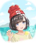  1girl :d ayaro_(genkiloobaii) bangs beanie black_hair blue_eyes blush cloud collarbone commentary_request day eyelashes floral_print hand_up hat highres looking_at_viewer open_mouth outdoors pokemon pokemon_(game) pokemon_sm red_headwear selene_(pokemon) shirt short_hair sky smile solo t-shirt teeth tongue upper_body upper_teeth_only water yellow_shirt 