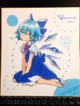  1girl artist_name bangs barefoot blue_bow blue_dress blue_eyes blue_hair bow cirno closed_mouth collared_shirt detached_wings dress fairy full_body hair_between_eyes hair_bow highres ice ice_wings namauni photo_(medium) puffy_short_sleeves puffy_sleeves shikishi shirt short_hair short_sleeves signature smile solo touhou traditional_media white_shirt wings 