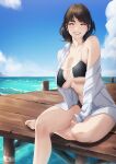  1girl bikini blueorca blush breasts brown_hair cleavage collared_shirt dock grin highres large_breasts looking_at_viewer mole mole_under_eye open_clothes open_shirt original outdoors pier scenery shirt single_bare_shoulder sitting sky smile solo swimsuit underboob water waves white_shirt 