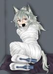  1girl animal_ears arknights bandages bdsm bondage bound commentary_request gagged grani_(arknights) grey_eyes grey_hair hair_between_eyes highres indoors long_hair looking_at_viewer mummification_(bound) ponytail sa@mobuliaoyu sitting socks solo tail v-shaped_eyebrows white_socks 