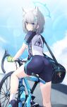  1girl animal_ear_fluff animal_ears ass bag bicycle blue_archive blue_eyes blush ddangbi from_behind gloves green_gloves grey_hair ground_vehicle hair_ornament halo highres looking_at_viewer looking_back outdoors shiroko_(blue_archive) shiroko_(cycling)_(blue_archive) short_sleeves shoulder_bag solo thighs 