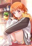  1girl ahoge blurry blurry_background blush braid clover_hair_ornament crossed_legs hair_ornament highres holding hood indoors inou_shin long_sleeves looking_at_viewer love_live! love_live!_sunshine!! open_mouth orange_hair red_eyes ribbon short_hair short_shorts shorts side_braid sitting solo takami_chika thighhighs white_thighhighs yellow_ribbon 