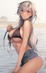  1girl alternate_hairstyle asymmetrical_bangs bikini bikini_top_only black_bikini blurry blurry_background breasts brown_eyes dark-skinned_female dark_skin denim denim_shorts facing_to_the_side from_side glasses grey_hair hair_down highres kantai_collection kasumi_(skchkko) large_breasts long_hair looking_at_viewer musashi_(kancolle) ocean outdoors parted_lips shorts smile solo swimsuit underboob wet 