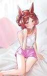  1girl alternate_costume animal_ears bare_shoulders bed_sheet blush breasts brown_hair closed_mouth commentary_request ear_ornament feet_out_of_frame hair_ornament highres horse_ears horse_girl looking_at_viewer navel on_bed parted_bangs pink_eyes pink_shorts sakura_laurel_(umamusume) short_hair shorts sitting small_breasts smile solo solokitsune tank_top umamusume white_tank_top yokozuwari 