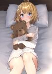  1girl absurdres b1ack_illust bed_sheet blush brown_hair collarbone commission doll_hug feet_out_of_frame highres idolmaster idolmaster_million_live! looking_at_viewer lying no_pants object_hug on_back pillow pixiv_commission shirt solo stuffed_animal stuffed_toy suou_momoko tears teddy_bear white_shirt 