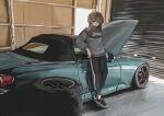  1girl absurdres black_pants bokuya brown_hair car full_body garage green_eyes ground_vehicle highres honda honda_s2000 indoors jacket looking_at_viewer medium_hair motor_vehicle original pants solo standing track_jacket vehicle_focus 