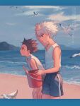  2boys beach bird black_hair blue_eyes blue_sky bucket cloud day gon_freecss highres holding hunter_x_hunter kiko killua_zoldyck leaning_forward male_focus multiple_boys outdoors profile red_eyes shorts sky sleeveless spiked_hair tank_top water wet white_hair white_tank_top 