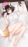  1girl absurdres animal_ears barefoot bed bedroom blue_archive bottomless brown_hair cellphone closed_mouth commentary_request fox_ears fox_girl fox_tail full_body hair_ornament highres holding holding_phone indoors izuna_(blue_archive) karurega no_panties on_bed phone pom_pom_(clothes) pom_pom_hair_ornament shirt short_hair short_sleeves smartphone smile solo t-shirt tail white_shirt yellow_eyes 