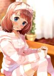  1girl :d blue_eyes blush bow brown_hair commentary couch cup curtains dot_nose feet_out_of_frame hair_bow hairband highres holding holding_cup hood hoodie hot_chocolate idolmaster idolmaster_million_live! indoors looking_at_viewer nira_(vira) plant potted_plant short_hair sitting smile suou_momoko thighhighs zettai_ryouiki 