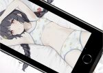  1girl armpits arms_up bed bed_sheet bikini black_hair blue_archive braid cellphone chestnut_mouth collarbone commentary flat_chest halo highres leaf leaf_on_head leaf_print light_blush long_hair looking_at_viewer lying miyu_(blue_archive) miyu_(swimsuit)_(blue_archive) navel on_back phone photo_(object) print_bikini rauto red_eyes sidelocks smartphone solo stomach swimsuit twin_braids white_bikini 
