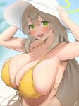 1girl bikini blue_archive blurry blurry_background breasts brown_hair green_eyes hair_between_eyes halo hat highres huge_breasts long_hair looking_at_viewer nekoshoko nonomi_(blue_archive) nonomi_(swimsuit)_(blue_archive) official_alternate_costume open_mouth round_teeth smile solo swimsuit teeth upper_body upper_teeth_only white_headwear yellow_bikini yellow_halo 