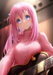  1girl absurdres blue_eyes blurry blurry_background blush bocchi_the_rock! breasts chinese_commentary closed_mouth commentary_request crossed_bangs cube_hair_ornament eyelashes from_below frown glint gotoh_hitori guitar hair_between_eyes hair_ornament hair_over_shoulder highres holding holding_instrument indoors instrument jacket large_breasts long_hair long_sleeves looking_at_viewer looking_down one_side_up pink_hair pink_jacket royboy sidelocks solo stage tareme track_jacket upper_body wide-eyed 