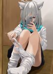 1girl absurdres animal_ear_fluff animal_ears bare_legs blue_archive blue_skirt grey_hair halo highres holding holding_phone indoors knees_up looking_at_phone mirror panties panties_around_one_leg panty_pull phone reflection selfie shiroko_(blue_archive) shirt sitting skirt socks solo szm37373 underwear white_panties white_shirt white_socks wolf_ears 