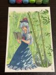  1girl art_tools_in_frame bamboo bamboo_forest blue_dress blue_hair blue_headwear blush book border collared_dress dappled_sunlight dress fading_border feet_out_of_frame forest hands_up hat highres holding holding_book kamishirasawa_keine light_blue_hair long_hair looking_at_viewer marker marker_(medium) nature neckerchief open_book open_mouth outside_border photo_(medium) puffy_short_sleeves puffy_sleeves raised_eyebrows red_eyes red_neckerchief rock shiratama_(hockey) short_sleeves sidelocks signature solo sunlight touhou traditional_media white_border 