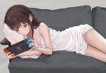  1girl akipeko bare_shoulders brown_hair closed_mouth commentary_request couch dress expressionless grey_background handheld_game_console long_hair lying nintendo_switch on_couch on_side original panties pantyshot pillow playing_games red_eyes simple_background sleeveless sleeveless_dress solo thighs underwear white_dress 