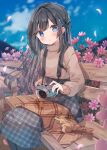  1girl black_hair blue_eyes blush camera dress flower heripiro highres holding holding_camera long_hair long_sleeves looking_at_viewer open_mouth original pink_flower sitting solo sweater 