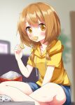  1girl blurry blurry_background blush book breasts brown_eyes brown_hair casual character_request chips_(food) copyright_request crossed_legs eating food food_in_mouth hair_between_eyes highres looking_at_viewer medium_hair potato_chips ruu_(tksymkw) shorts small_breasts solo 