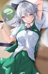  1girl 258n absurdres black_hairband blue_eyes blush breasts green_skirt green_vest grey_hair hairband hand_fan highres holding holding_fan konpaku_youmu looking_at_viewer lying medium_breasts midriff_peek navel on_back paper_fan shirt short_hair skirt solo sweatdrop tatami touhou translated vest white_shirt 