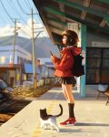  1girl animal backpack bag black_skirt blurry blurry_background brown_hair cat cellphone commentary english_commentary from_side full_body highres holding holding_phone jacket kneehighs long_sleeves mountain original outdoors phone profile railroad_tracks red_jacket sam_yang shoes short_hair skirt smile sneakers socks solo train_station 