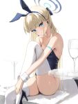  1girl absurdres animal_ears arm_strap bare_shoulders blonde_hair blue_archive blue_eyes blue_leotard braid breasts commentary cup detached_collar drinking_glass fake_animal_ears halo hidulume high_heels highres knee_up leotard long_hair looking_at_viewer medium_breasts multicolored_hair official_alternate_costume playboy_bunny rabbit_ears solo strapless strapless_leotard streaked_hair thighhighs thighs toki_(blue_archive) toki_(bunny)_(blue_archive) very_long_hair white_thighhighs wine_glass wrist_cuffs 
